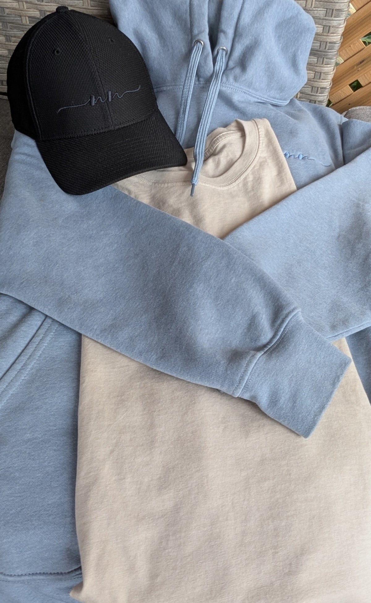 Nautically Nice Coastal Cap, Skystone hoodie, and Dunedrift tee styled together showing a mix of the Coastal palette